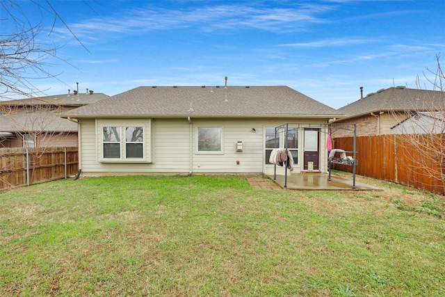 rear view of property with a patio, a yard, and a fenced backyard