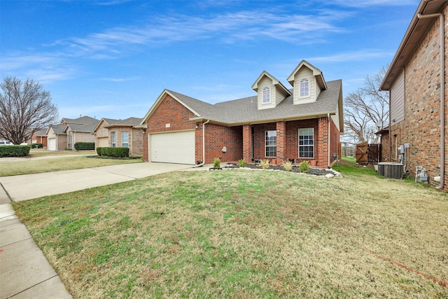 view of front of property with brick siding, central air condition unit, a front lawn, concrete driveway, and an attached garage