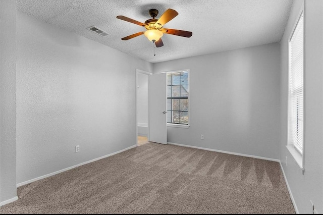 5316 Columbia Ave, Dallas, TX 75214 - carpeted empty room with baseboards, visible vents, a ceiling fan, and a textured ceiling