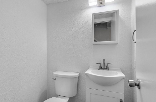 5316 Columbia Ave, Dallas, TX 75214 - bathroom featuring toilet, a textured wall, and vanity