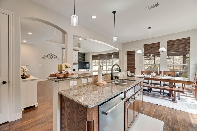 kitchen with visible vents, arched walkways, dishwasher, a sink, and open floor plan