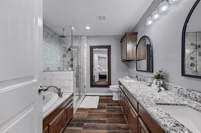 717 S Elm St, Sherman, TX 75090 - full bath with a shower stall, a sink, double vanity, a garden tub, and wood finished floors