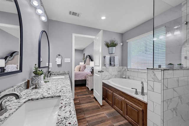 717 S Elm St, Sherman, TX 75090 - ensuite bathroom with a bath, a sink, wood finished floors, and ensuite bathroom