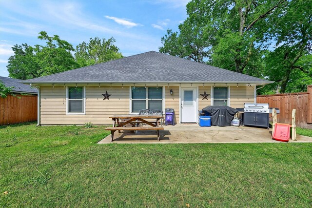 717 S Elm St, Sherman, TX 75090 - rear view of property featuring a lawn, a patio, a shingled roof, and a fenced backyard