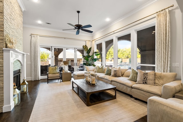 living room with crown molding, a ceiling fan, and wood finished floors