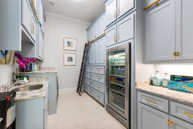 interior space featuring beverage cooler, a sink, baseboards, visible vents, and crown molding