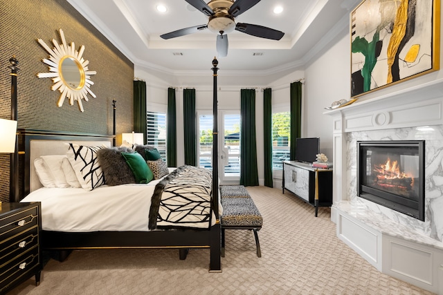 carpeted bedroom with crown molding, a fireplace, recessed lighting, and a tray ceiling