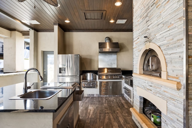 kitchen with recessed lighting, a sink, dark wood-style flooring, wall chimney range hood, and wood ceiling