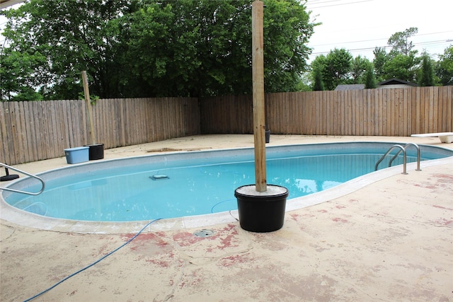 view of swimming pool featuring a diving board, a patio, a fenced in pool, and a fenced backyard