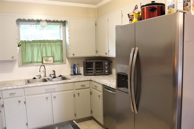 kitchen with crown molding, a sink, appliances with stainless steel finishes, light countertops, and a toaster