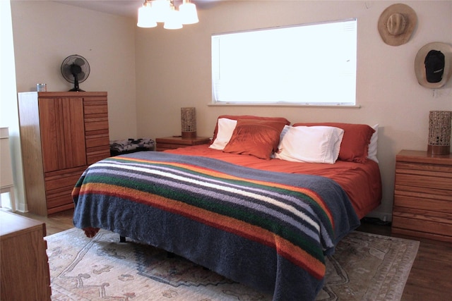 bedroom featuring wood finished floors and a notable chandelier