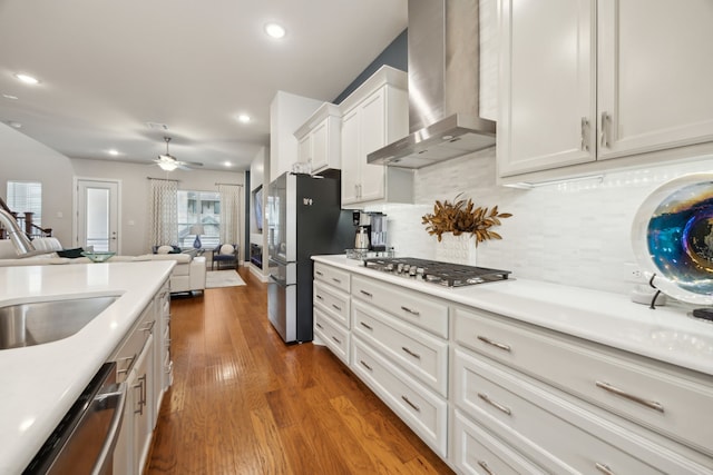 8218 Laflin Ln, Dallas, TX 75231 - kitchen featuring open floor plan, wall chimney range hood, recessed lighting, white cabinetry, and stainless steel appliances