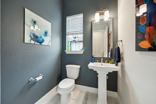 8218 Laflin Ln, Dallas, TX 75231 - bathroom featuring baseboards, toilet, and marble finish floor