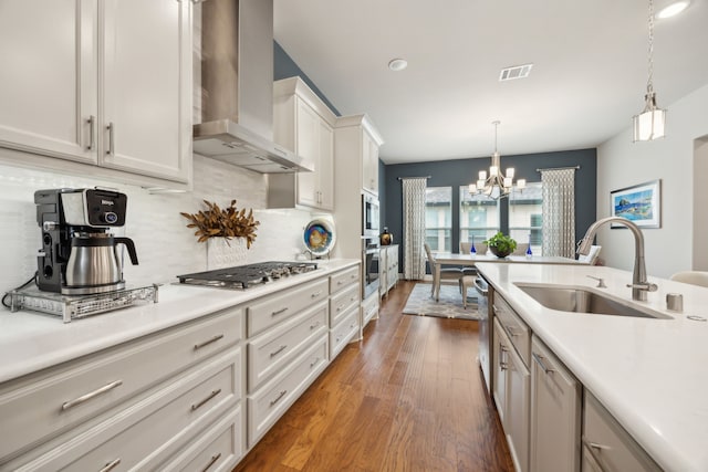 8218 Laflin Ln, Dallas, TX 75231 - kitchen with wall chimney range hood, a sink, light countertops, stainless steel appliances, and visible vents