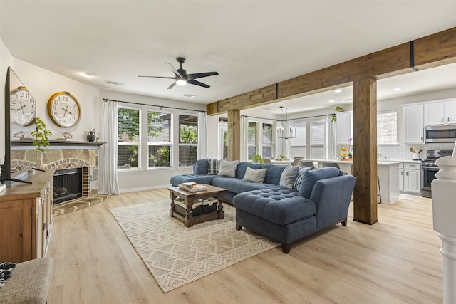 living area featuring ceiling fan, a stone fireplace, recessed lighting, light wood-type flooring, and visible vents