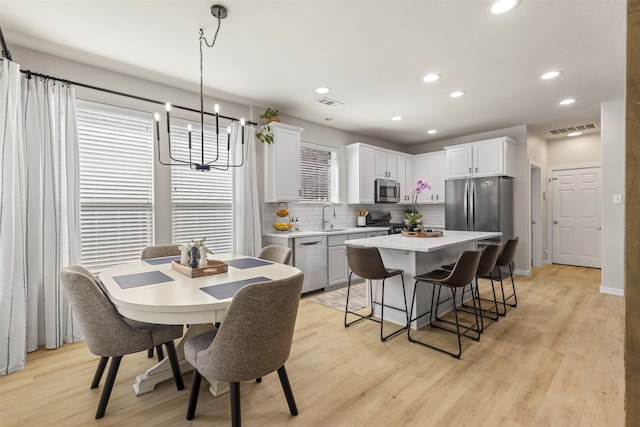 dining room featuring recessed lighting, a chandelier, visible vents, and light wood-style floors