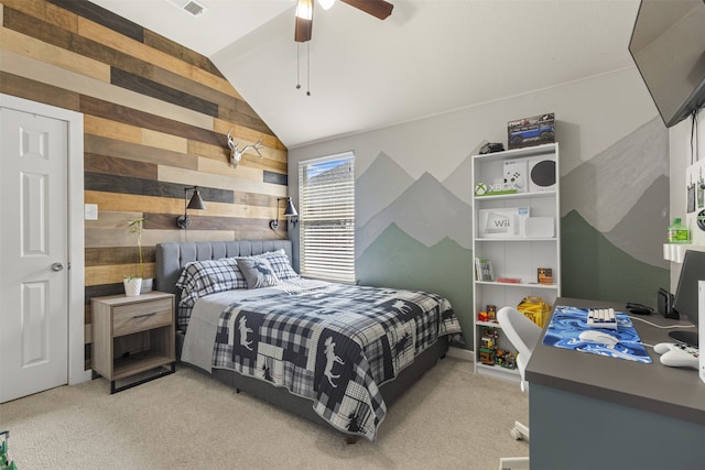 bedroom featuring ceiling fan, light carpet, vaulted ceiling, and wood walls