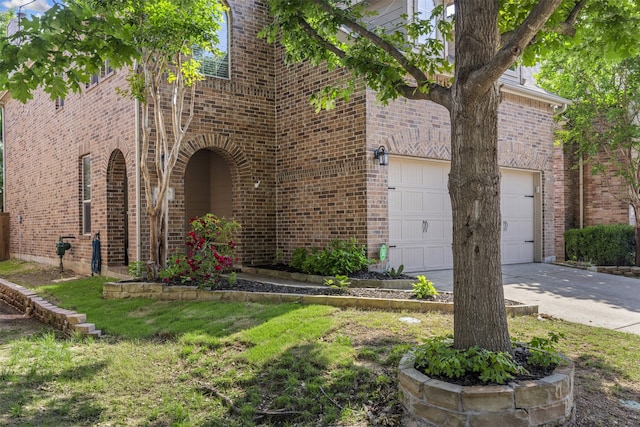 view of front facade with brick siding, a garage, and driveway