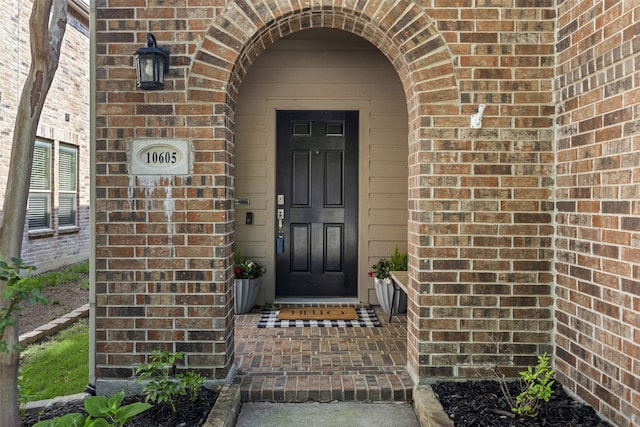 doorway to property with brick siding