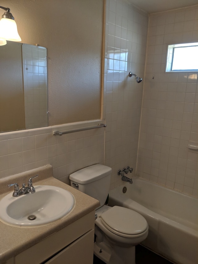 full bathroom with toilet, vanity, bathtub / shower combination, and tile walls