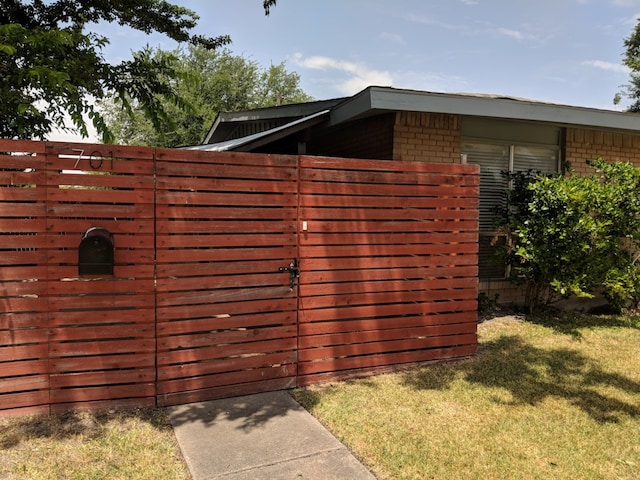 view of gate featuring a yard and fence