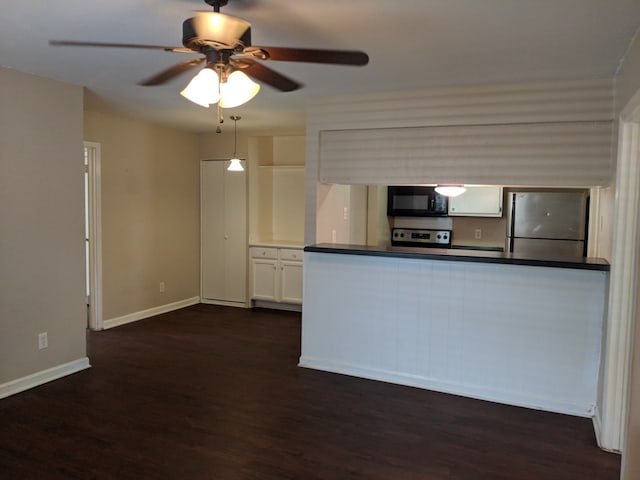 kitchen with white cabinetry, dark countertops, appliances with stainless steel finishes, and dark wood-type flooring