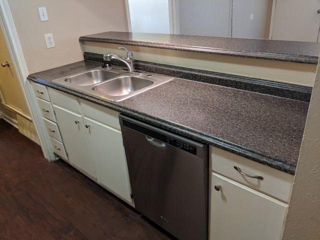 kitchen with dark countertops, dishwasher, dark wood finished floors, and a sink