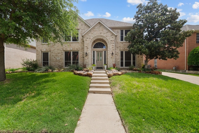 traditional-style house featuring brick siding and a front yard