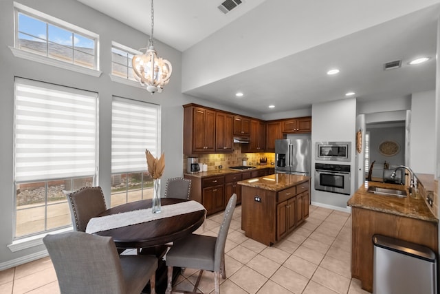 kitchen with tasteful backsplash, a sink, visible vents, stainless steel appliances, and an inviting chandelier