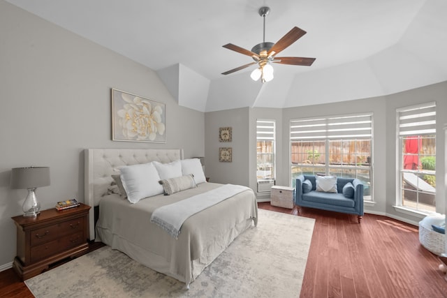 bedroom featuring baseboards, wood finished floors, a ceiling fan, and multiple windows