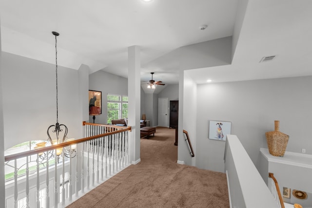 hallway with an upstairs landing, carpet, visible vents, and a chandelier
