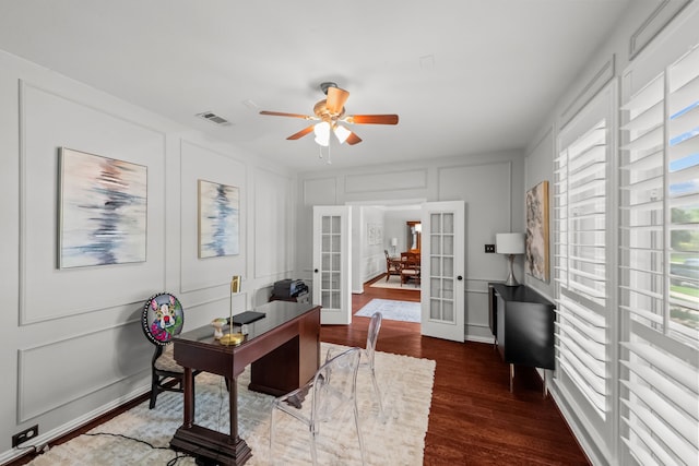office space with ceiling fan, a decorative wall, visible vents, dark wood finished floors, and french doors