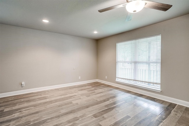 spare room featuring baseboards, recessed lighting, ceiling fan, and light wood finished floors