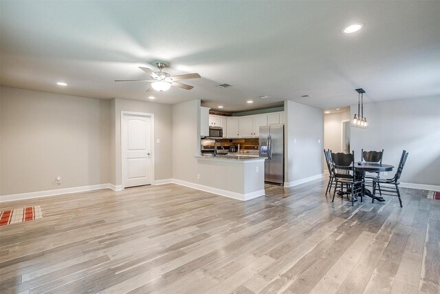 living area with recessed lighting, baseboards, and light wood-type flooring