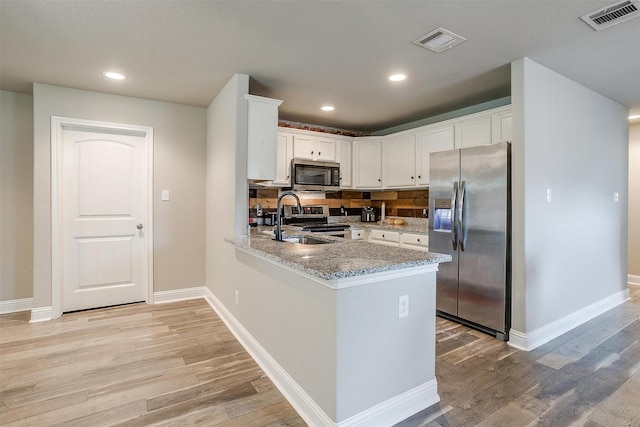 kitchen featuring light wood-style flooring, visible vents, white cabinetry, and stainless steel appliances