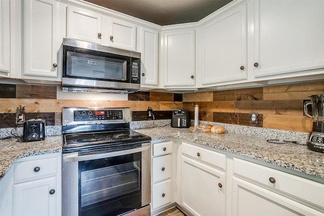 kitchen with white cabinetry, stainless steel appliances, and decorative backsplash