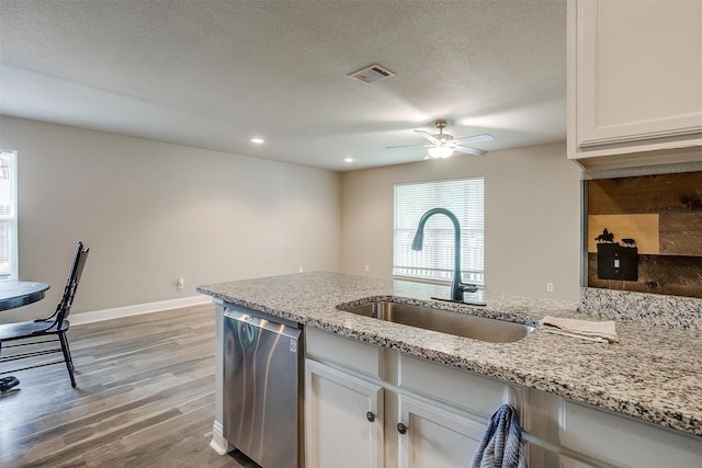 kitchen featuring light stone counters, ceiling fan, dishwasher, a sink, and light wood-type flooring