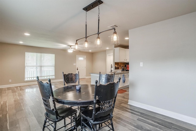 dining space with light wood-style floors, recessed lighting, and baseboards