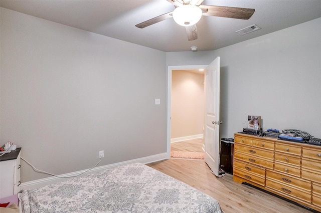 bedroom with baseboards, visible vents, light wood-type flooring, and ceiling fan