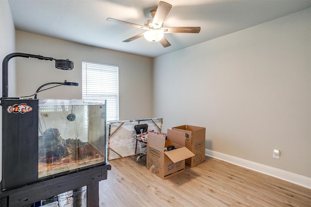 misc room with ceiling fan, light wood-style flooring, and baseboards