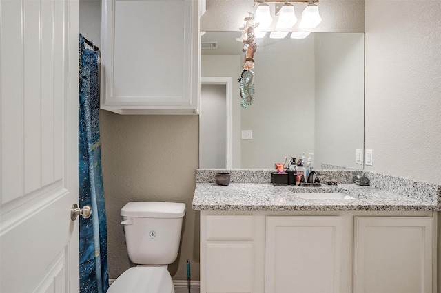 full bathroom with a textured wall, vanity, toilet, and visible vents