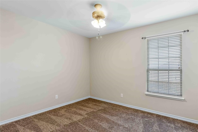 carpeted spare room featuring baseboards