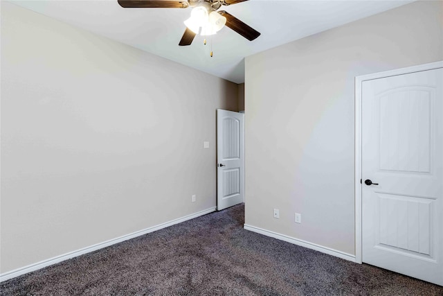 unfurnished bedroom featuring a ceiling fan, dark carpet, and baseboards