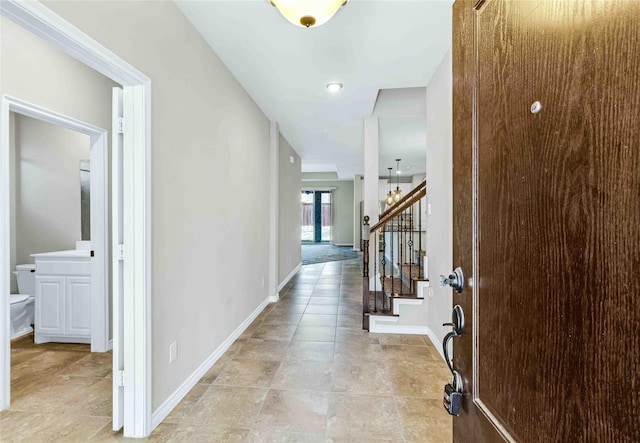 hallway with stairway and baseboards