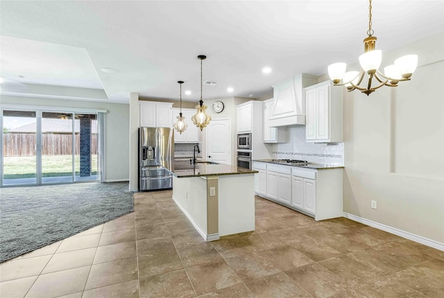 kitchen featuring a sink, a chandelier, stainless steel appliances, baseboards, and premium range hood