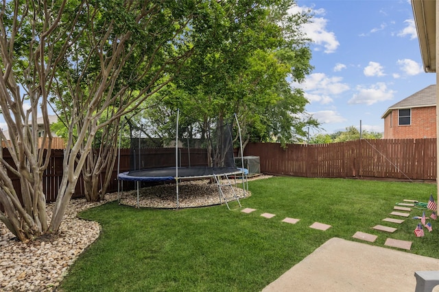 view of yard featuring a trampoline, a patio, and a fenced backyard