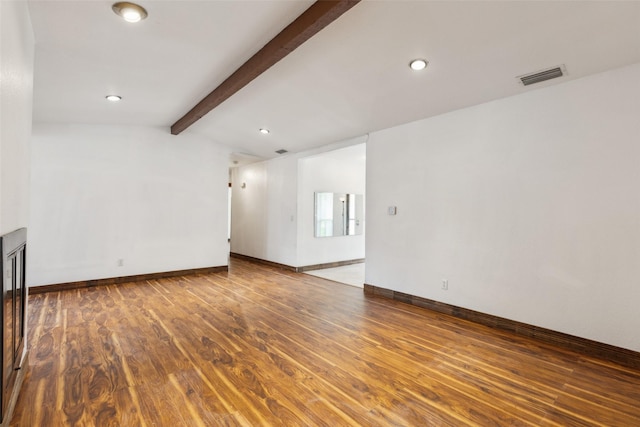 unfurnished living room with lofted ceiling with beams, recessed lighting, baseboards, wood finished floors, and visible vents