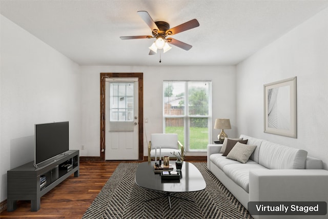 living area featuring baseboards, a ceiling fan, and dark wood-style flooring