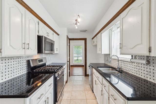 416 Cambridge Dr, Richardson, TX 75080 - kitchen with appliances with stainless steel finishes, a sink, backsplash, and white cabinets