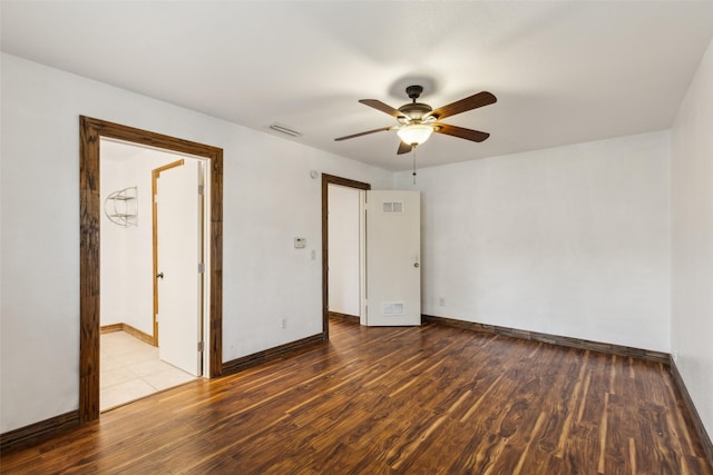 spare room with baseboards, ceiling fan, visible vents, and wood finished floors